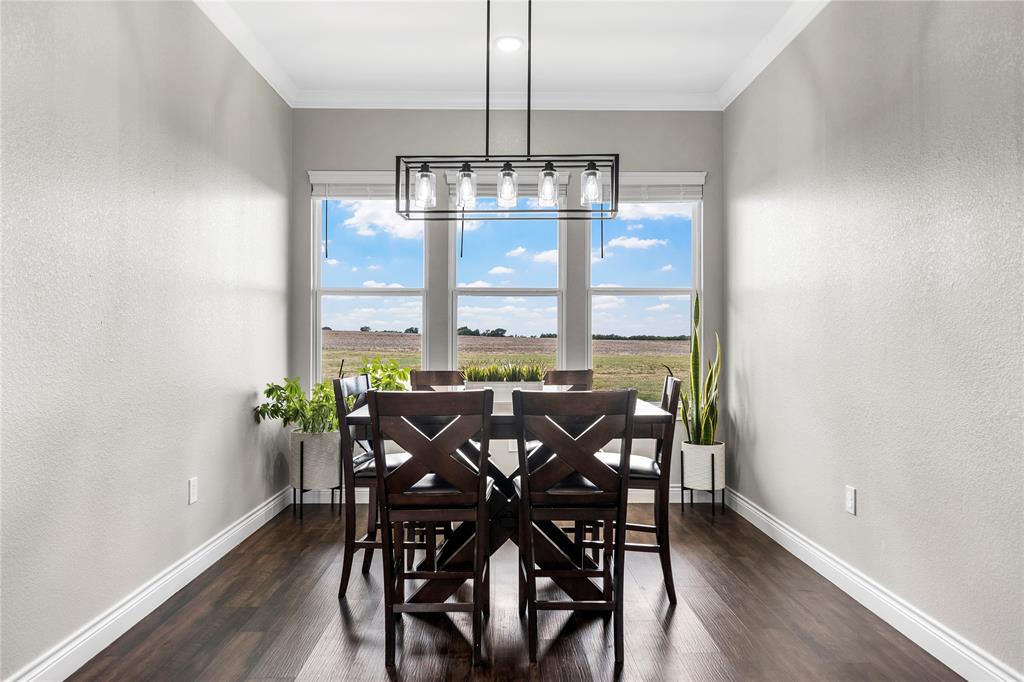 Triple windows with crown molding, dark wood-finish flooring, and a linear five-light rectangular chandelier
