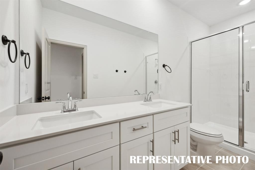 Ample room for two in this lovely owner's bath featuring dual vanity sinks and spacious walk in shower.  REPRESENTATIVE PHOTO