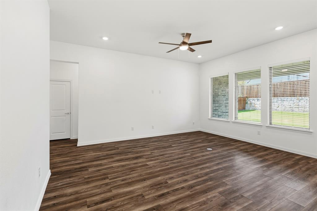 Interior space featuring wood-finish flooring, recessed lighting, a ceiling fan with integrated light fixture, and three large windows