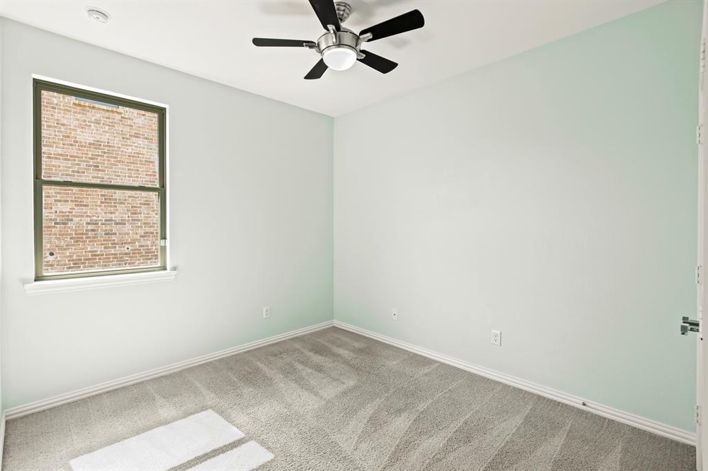 Neutral-toned wall paint, wall-to-wall carpeting, brushed-nickel ceiling fan with integrated lighting, and a single-hung window featuring a masonry exterior