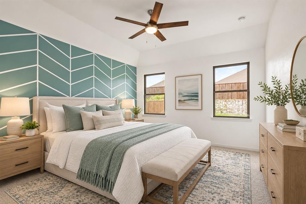 Room featuring a tray ceiling, geometric accent wall, and a five-blade ceiling fan with integrated lighting. Virtual photo