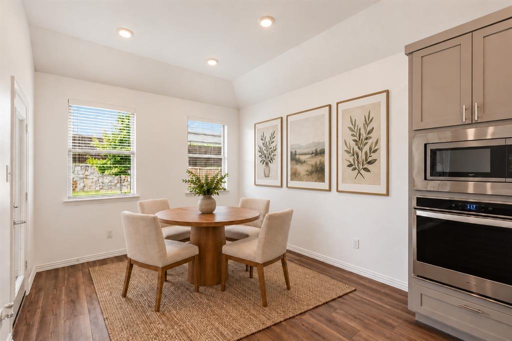 Vaulted ceiling, wood-finish flooring, recessed lighting, and built-in stainless steel double wall oven and microwave. Virtual photo