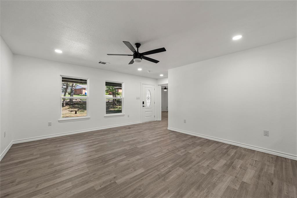 Neutral interior featuring wood-finish flooring, recessed lighting, a modern ceiling fan, and double-pane windows
