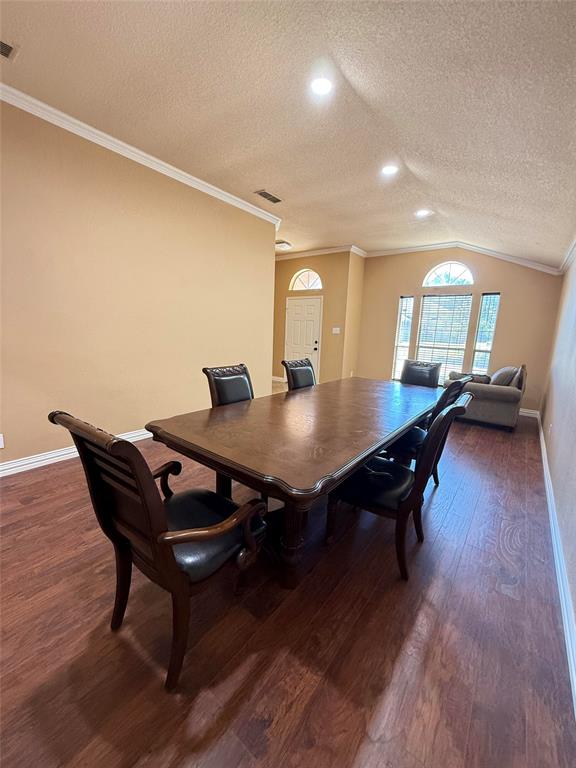 Vaulted ceilings, wood-finish flooring, recessed lighting, crown molding, and arched window detailing