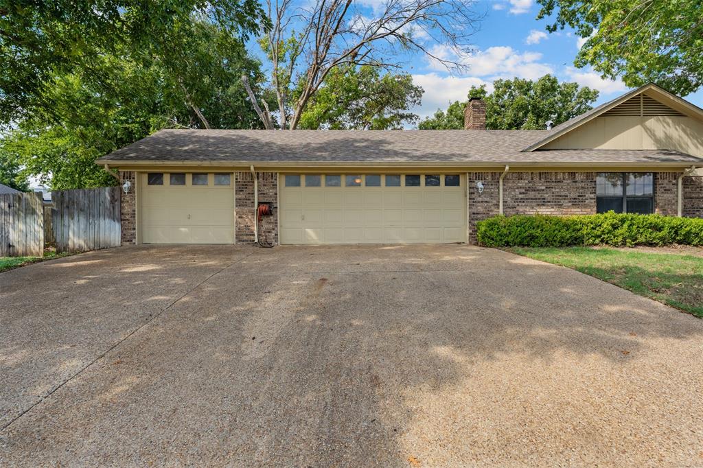 Brick and siding exterior featuring a three-car garage, concrete driveway, and asphalt shingle roof