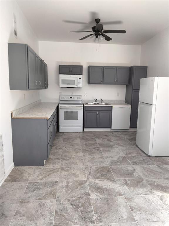 Kitchen featuring gray cabinetry, stone-finish countertops, tile flooring, integrated ceiling fan, and built-in appliances