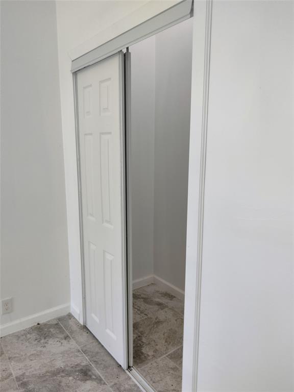 Six-panel sliding door featuring a white finish and neutral stone-finish tile flooring