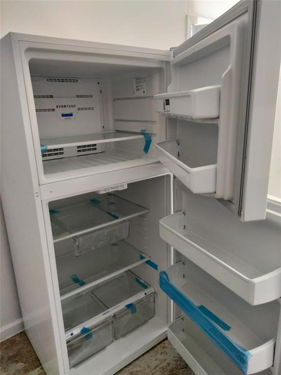 Top-mount refrigerator featuring a white finish, adjustable shelving, integrated door storage bins, and clear crisper drawers