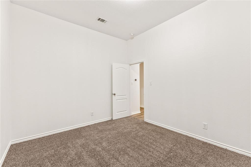 Interior room featuring neutral wall paint, carpeted flooring, and a single-panel interior door