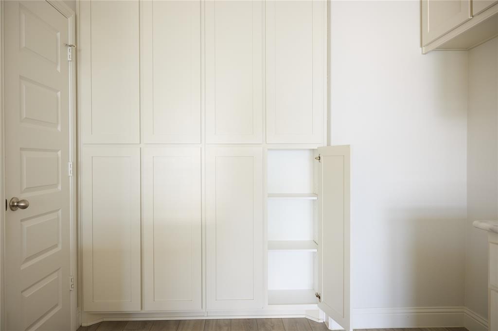 Floor-to-ceiling built-in cabinetry featuring Shaker-style doors, integrated shelving, and neutral-finish hardware