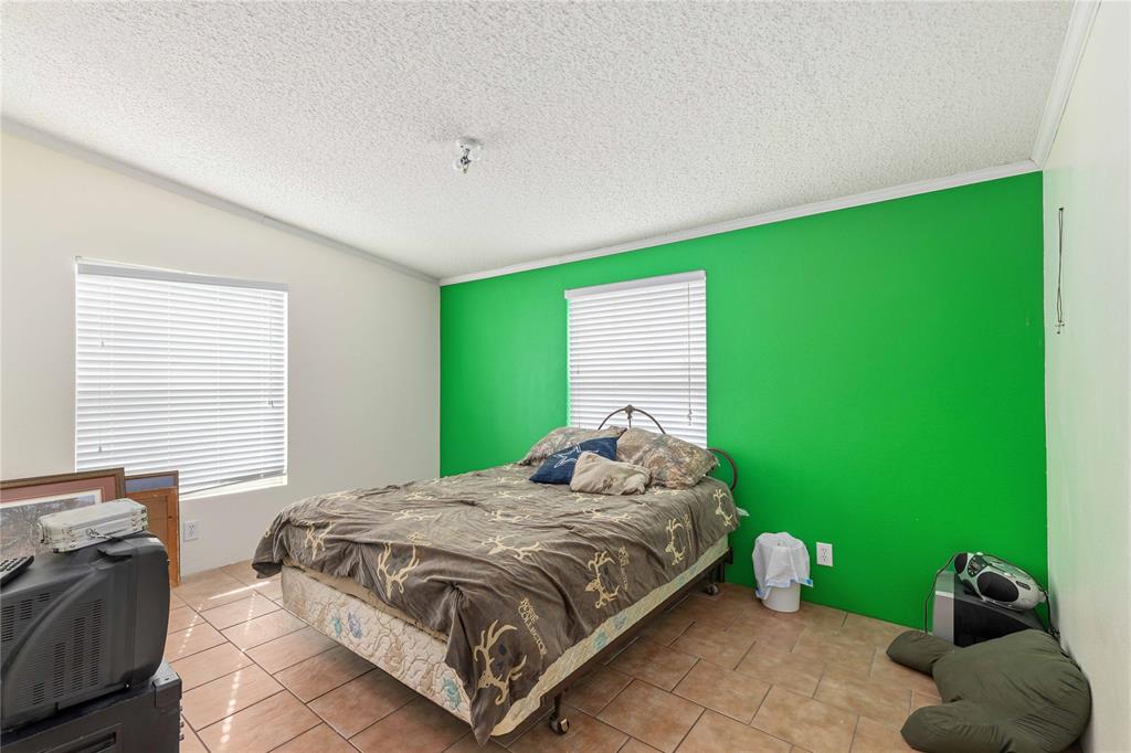 Room featuring ceramic tile flooring, dual windows with horizontal blinds, and a central ceiling light fixture