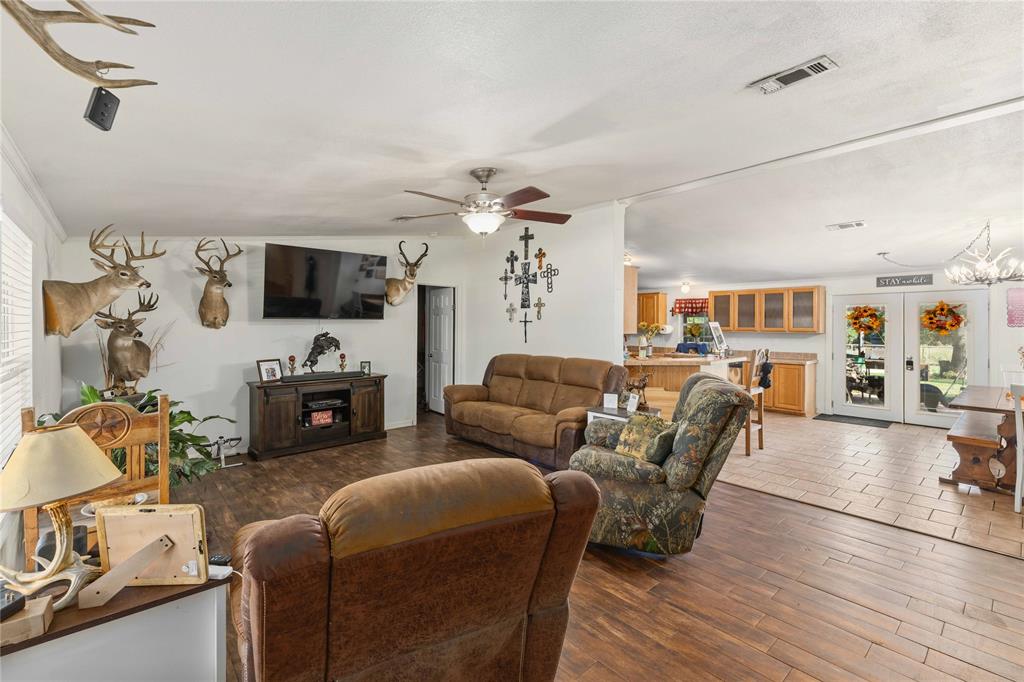Open floor plan featuring wood-finish flooring, recessed lighting, a ceiling fan with integrated light kit, and double French doors