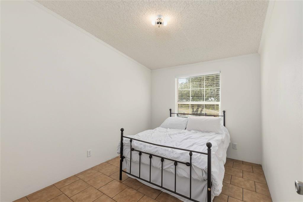Interior room featuring ceramic tile flooring, neutral walls, and a single-pane window with horizontal blinds