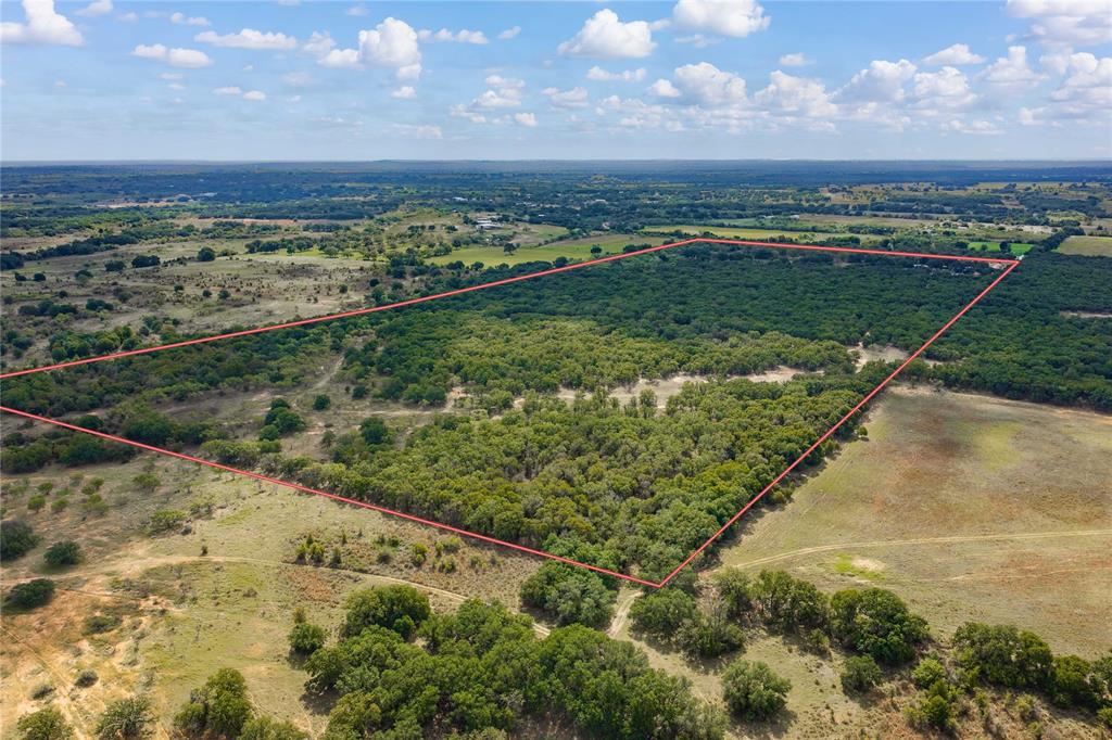 Expansive undeveloped acreage featuring diverse terrain, clusters of mature trees, and open meadow space