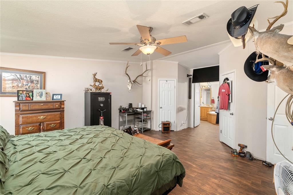 Interior space featuring wood-finish flooring, a ceiling fan with integrated lighting, and multiple interior doors with panel detailing