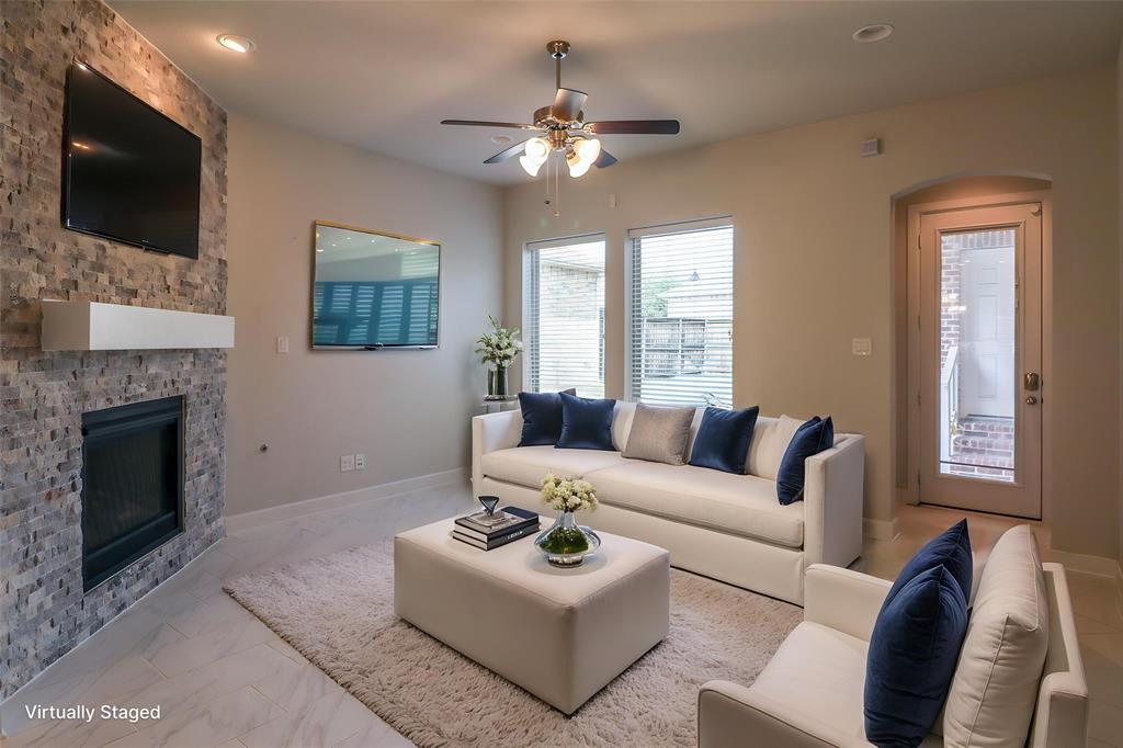Living room featuring a floor-to-ceiling textured stone fireplace surround, minimalist mantel, recessed ceiling lighting, ceiling fan with integrated lighting, and tile flooring
