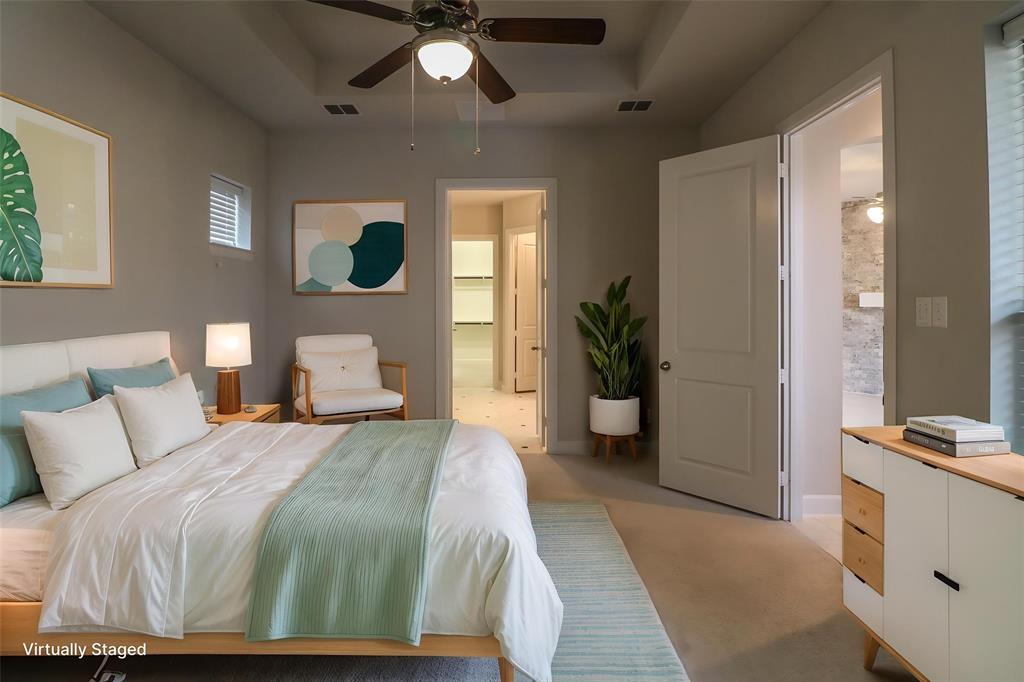 Bedroom featuring a tray ceiling, recessed lighting, neutral wall color, and a ceiling fan with integrated light fixture