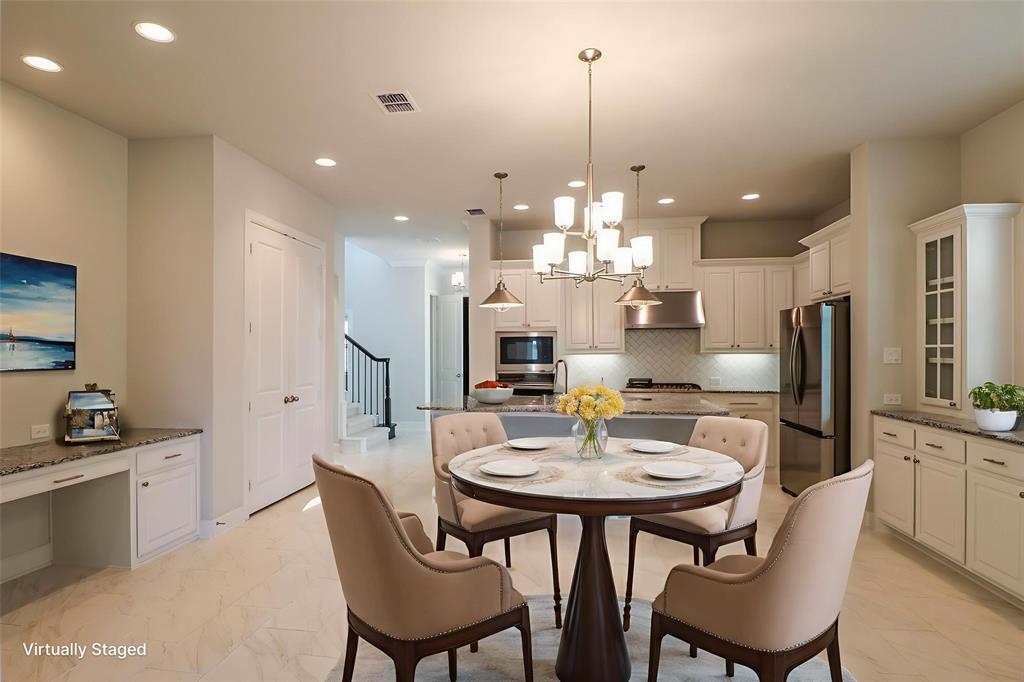 Kitchen featuring stone countertops, white shaker-style cabinetry, stainless steel appliances, a multi-light chandelier, and recessed lighting