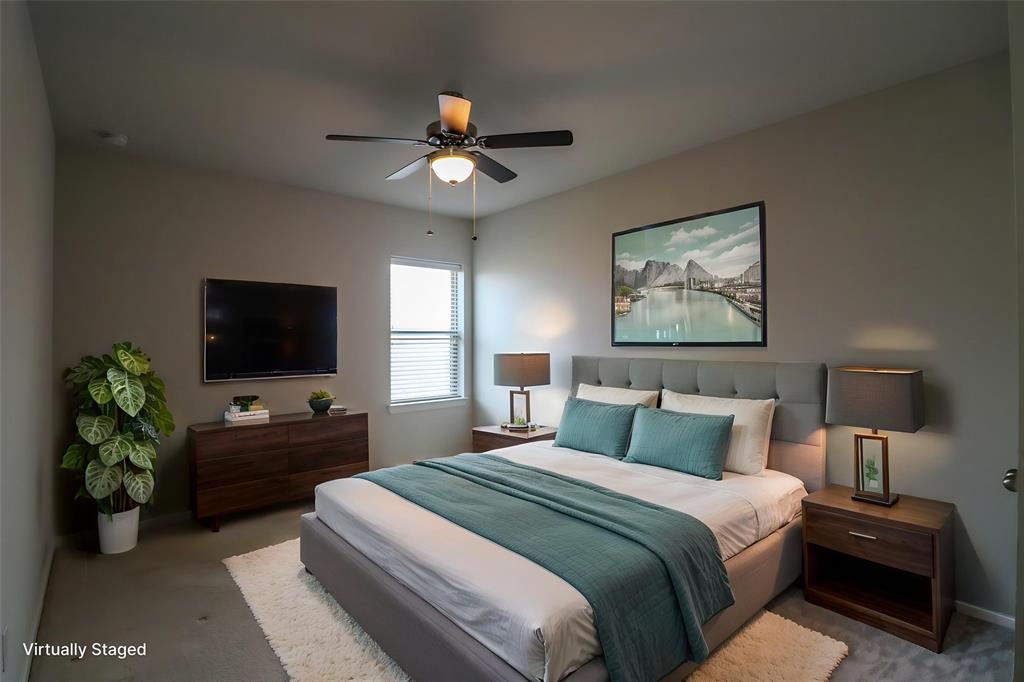 Neutral-toned interior featuring wall-to-wall carpeting, a multi-blade ceiling fan with integrated lighting, and a window with horizontal blinds