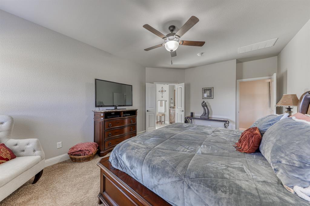 Room featuring neutral wall tones, carpeted flooring, a ceiling fan with integrated lighting, and dual doors