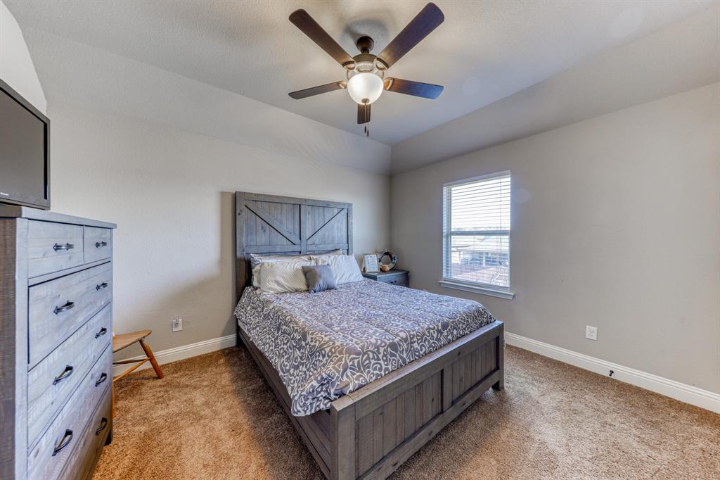 Tray ceiling featuring a central five-blade ceiling fan with integrated lighting and wall-to-wall carpeting