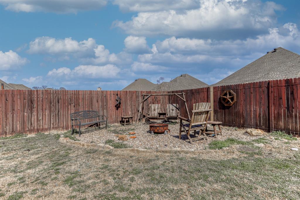 Backyard featuring a stained wood privacy fence and a gravel-surfaced ground area