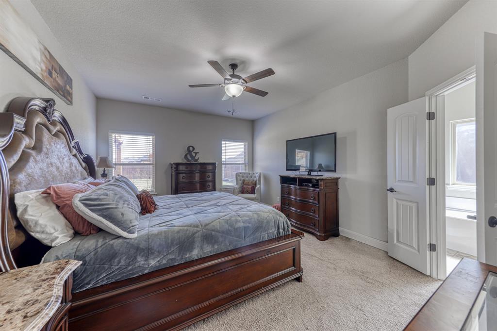 Neutral-toned room featuring wall-to-wall carpeting, ceiling fan with integrated lighting, and multiple windows