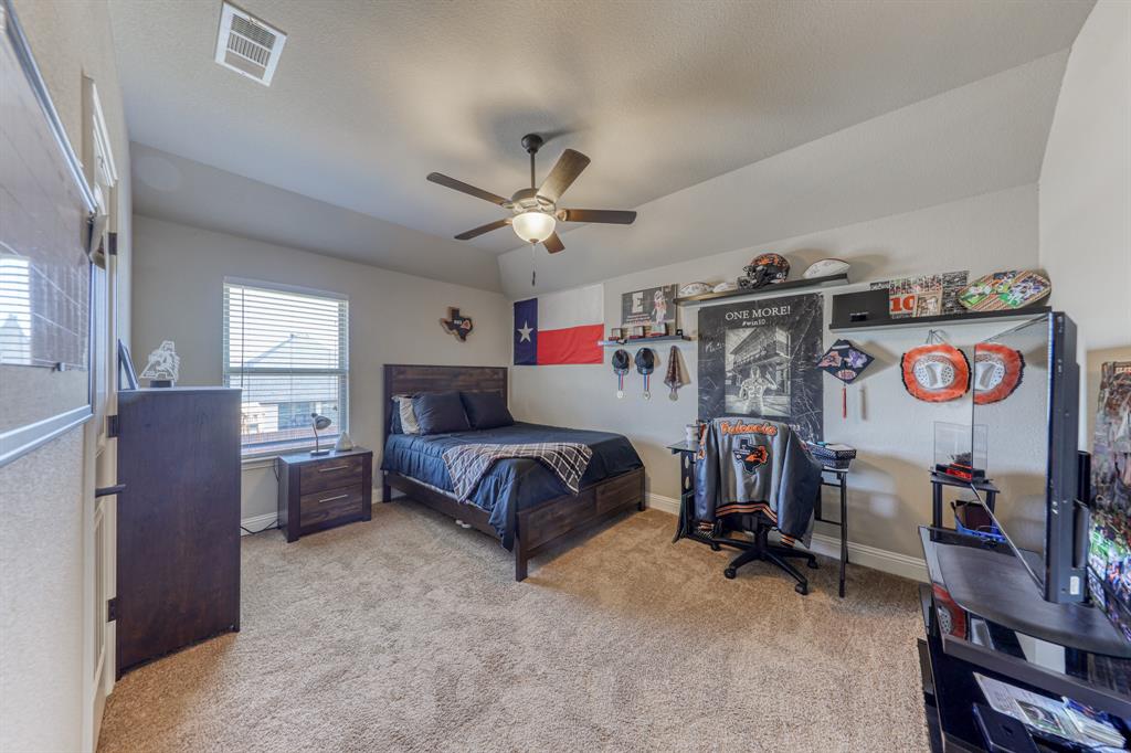 Vaulted ceiling featuring a central multi-blade ceiling fan and neutral wall-to-wall carpeting