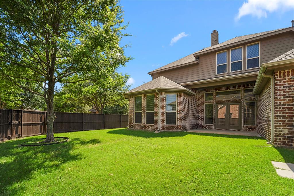 Exterior featuring brick and horizontal siding, a bay window configuration, double-glass entry doors, and a wood privacy fence