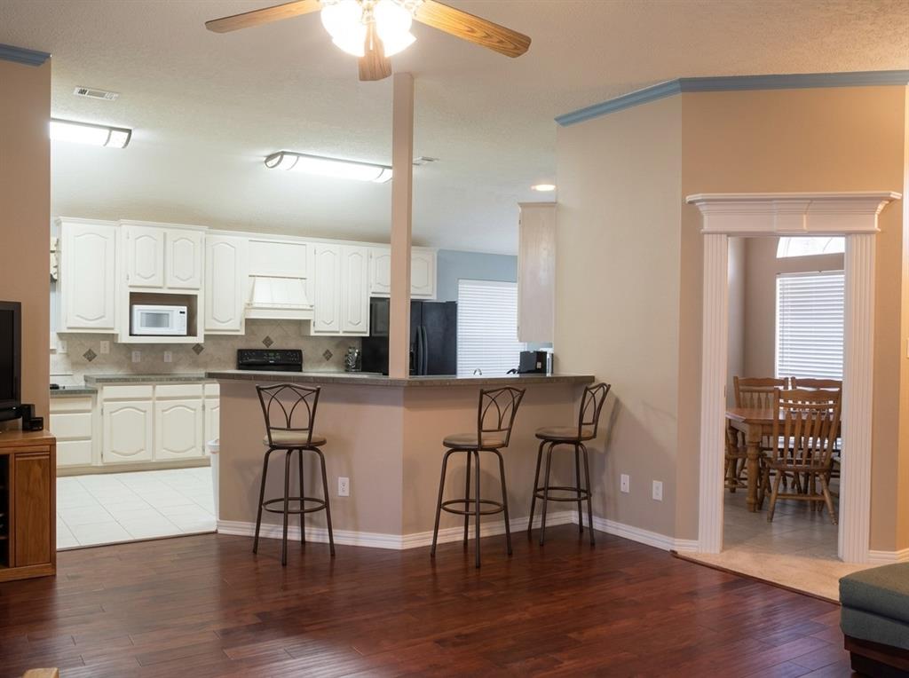 Kitchen featuring white cabinetry, solid-surface countertops, and a breakfast bar