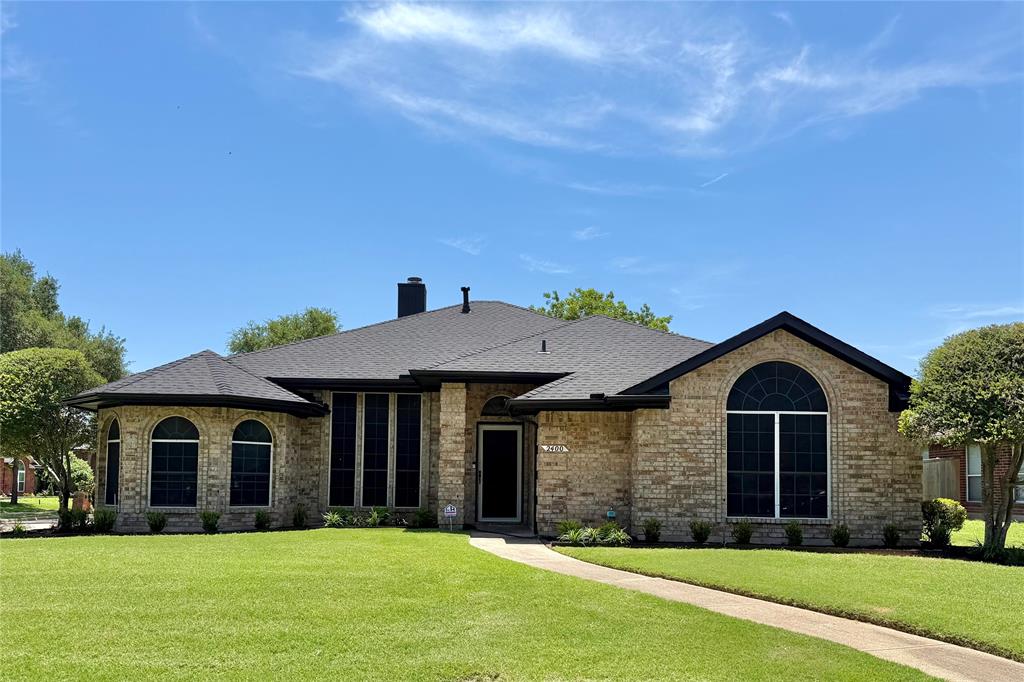 Single-story brick exterior featuring a multi-gabled roofline, prominent arched windows, and a paved walkway Single-story brick exterior featuring a multi-gabled roofline, prominent arched windows, and a paved walkway