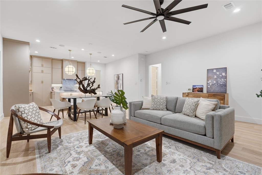 Open-concept interior featuring wood-finish flooring, recessed lighting, a modern ceiling fan, and built-in cabinetry with pendant lighting