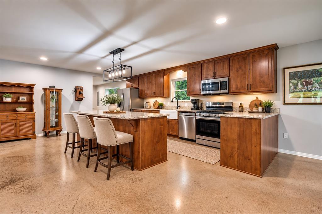 VIRTUALLY STAGED PHOTO – This image illustrates the kitchen's potential with updated bar stools and decorative accents. Virtual staging is for inspiration only; furnishings and décor shown are not included in the sale.