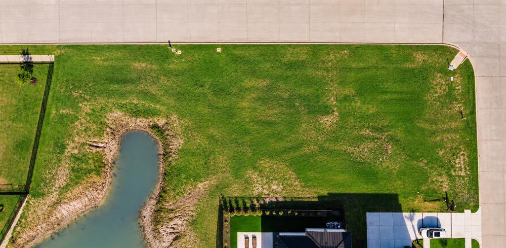 Corner lot featuring an expansive lawn, water feature, and concrete street access