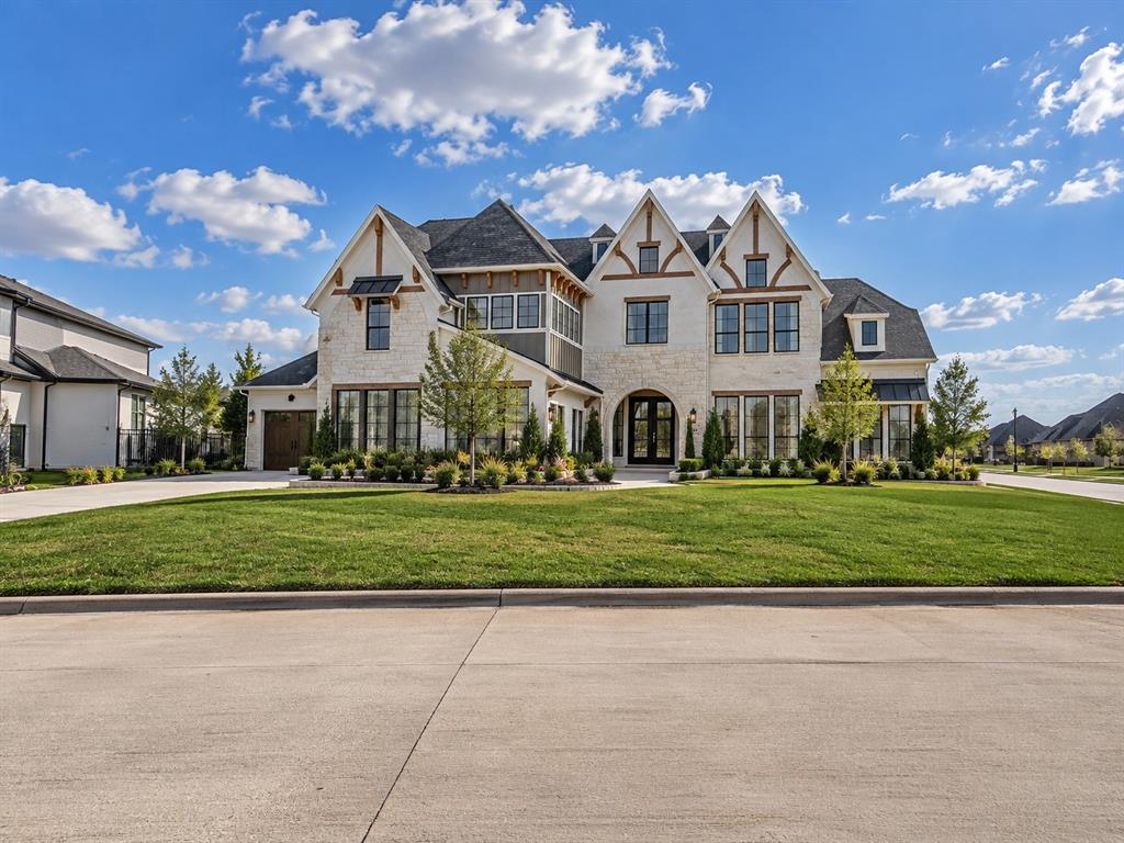 Custom multi-gabled exterior featuring masonry facade, decorative timber accents, arched entryway, and multi-paned windows