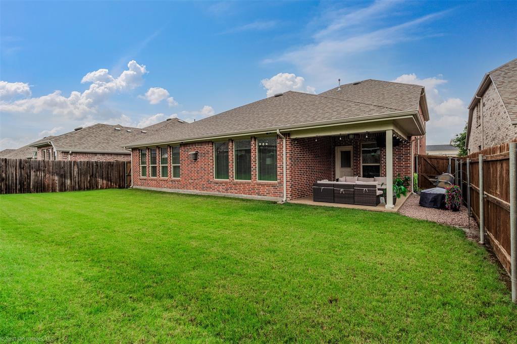 Rear view of property with an outdoor hangout area, a fenced backyard, brick siding, and a shingled roof