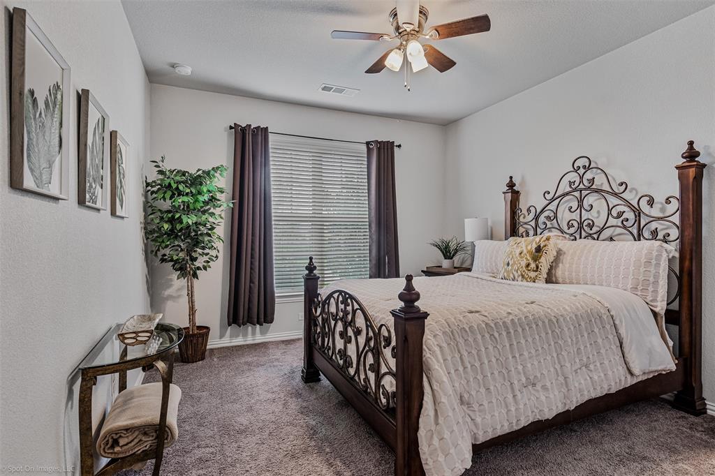 Carpeted bedroom with ceiling fan and baseboards