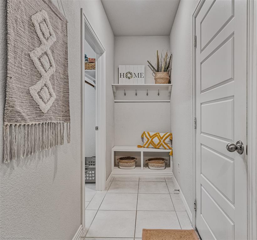 Mudroom featuring light tile patterned floors and baseboards