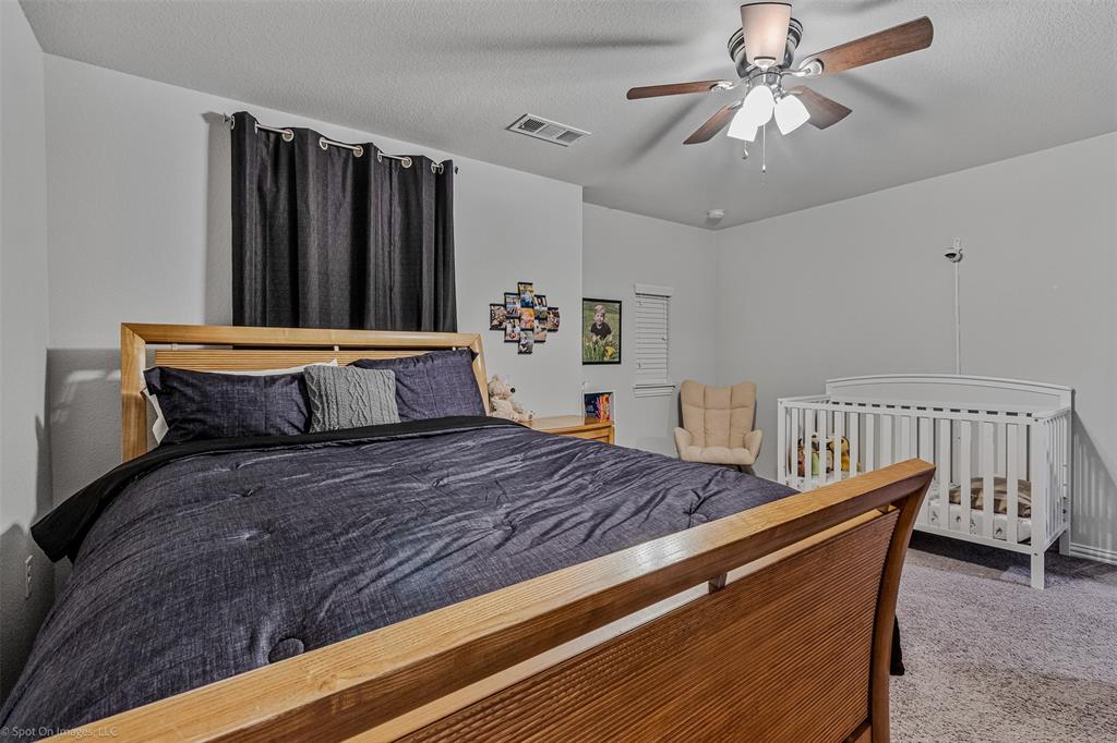 Carpeted bedroom featuring ceiling fan