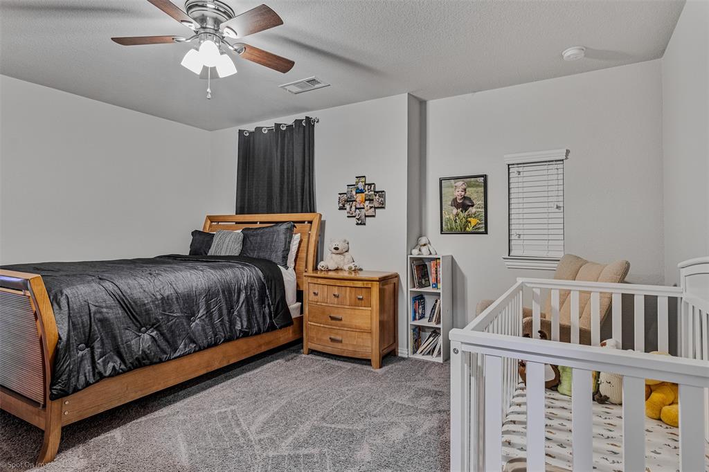 Carpeted bedroom featuring ceiling fan