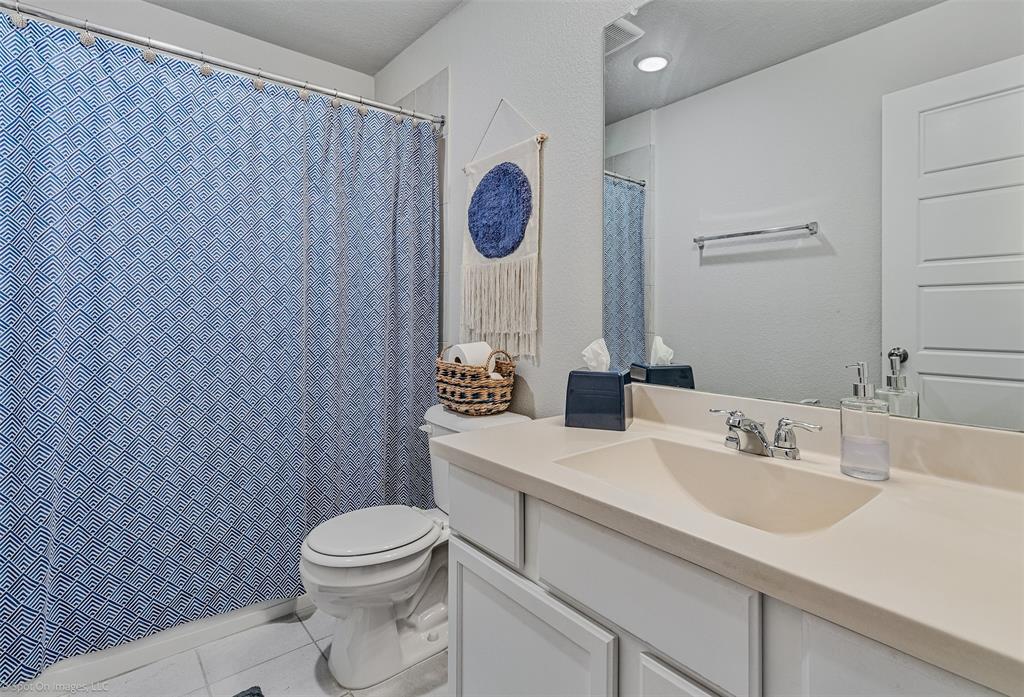 Full bathroom featuring tile patterned flooring, vanity, and curtained shower