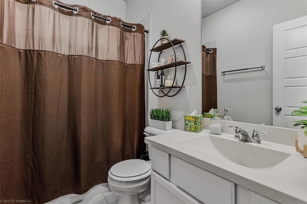 Bathroom featuring vanity, a shower with curtain, and a textured wall