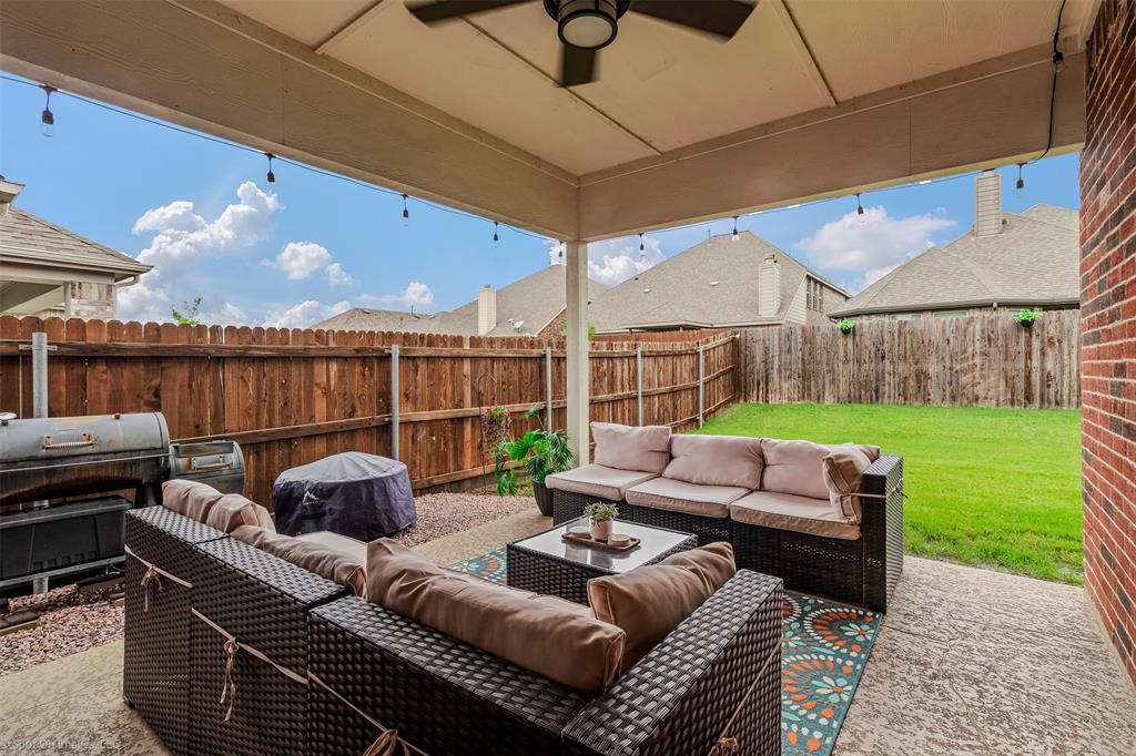 Fenced backyard with an outdoor hangout area, area for grilling, and a patio