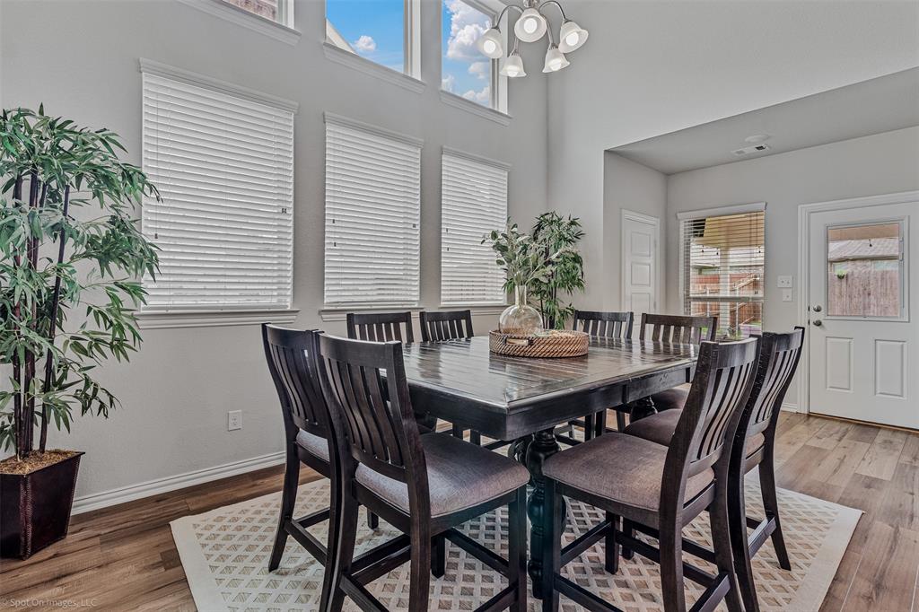 Dining room with light wood finished floors and a high ceiling