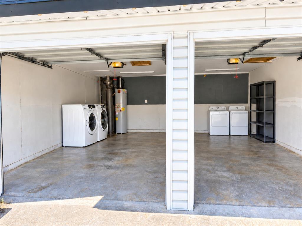 Two-car garage featuring a concrete floor, dual laundry hookups, and a water heater