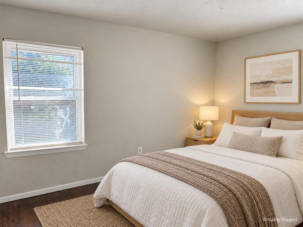 Neutral-toned walls, wood-finish flooring, and a window with horizontal blinds