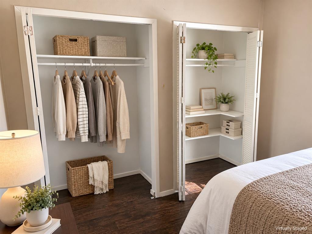 Dual closets featuring white accordion-style doors, interior shelving, and hanging rods over wood-finish flooring