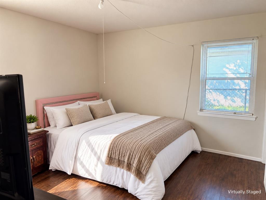 Neutral-toned wall finishes, wood-finish flooring, and a window fitted with horizontal blinds