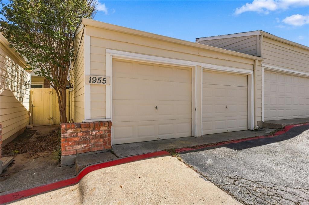 Two-car garage featuring horizontal siding, double sectional doors, and decorative brick masonry accents
