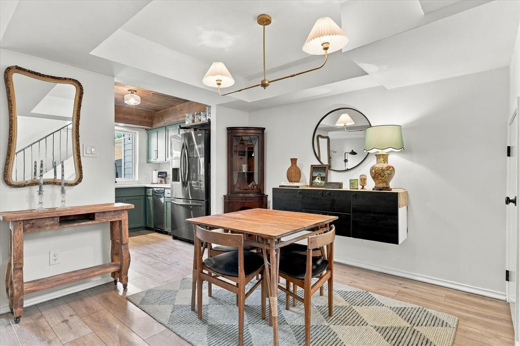 Tray ceiling with integrated lighting, wood-finish flooring, and wall-mounted cabinetry